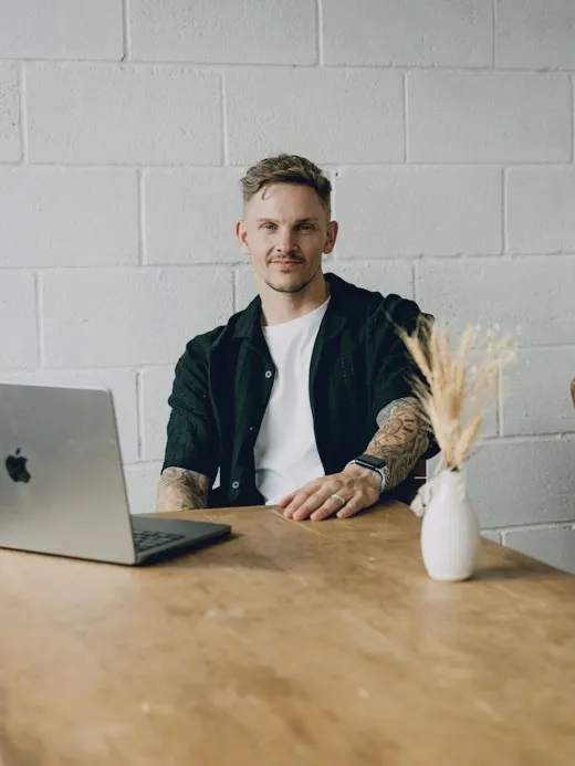 Man at a table with a laptop, ready for a call
