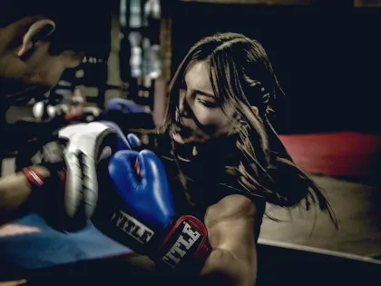 Woman training on boxing pads with a coach