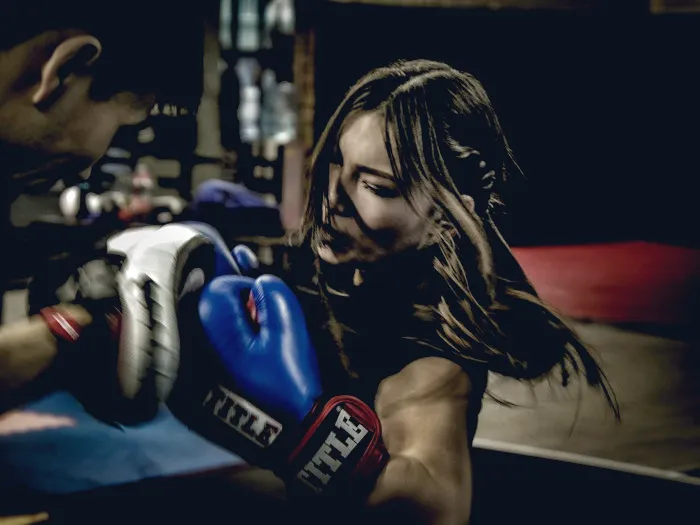 Woman training on boxing pads with a coach